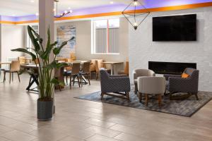 um átrio com uma mesa e cadeiras e uma lareira em La Quinta Inn & Suites by Wyndham Williston Burlington em Williston