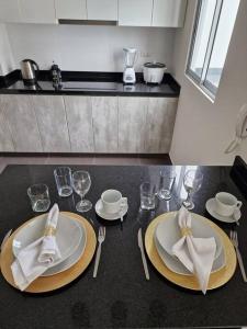 a table with two plates and glasses and napkins at Barranco Aparment Luxury in Lima