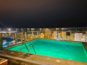 Barranco Aparment Luxury في ليما: مسبح فوق مبنى في الليل