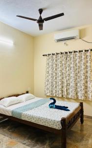 a bedroom with a bed with a ceiling fan at Friendly homestay in Mangalore-Greenview in Kankanādi
