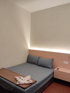 a bed with a towel on top of it at B & B 31 Kota Kinabalu in Kota Kinabalu