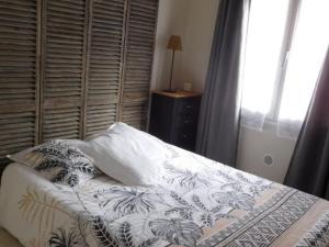 Schlafzimmer mit einem Bett mit einem Kissen und einem Fenster in der Unterkunft Maison La Faute-sur-Mer, 4 pièces, 5 personnes - FR-1-476-173 in La Faute-sur-Mer