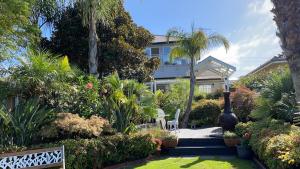 a house with a garden with trees and plants at Bayview Studio in Inverloch