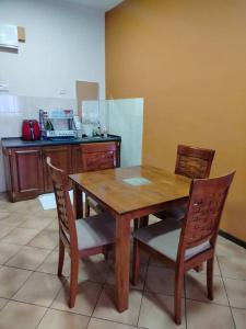 a wooden table and chairs in a kitchen at Homestay Elina - Cheap and cosy in Port Dickson