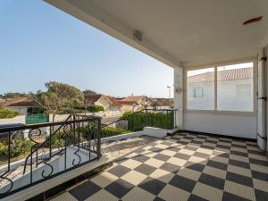 a balcony with a checkered floor at Maison 2* à 150m de l’océan, 6 pers, terrasse, jardin, proche activités - FR-1-50-93 in Mimizan +3 photos