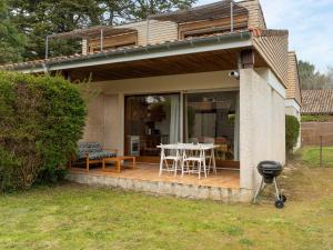 a house with a deck with a table and chairs at Maison 6 pers. à Mimizan, bord de courant, forêt et océan, 3 étoiles, tout confort, ménage inclus - FR-1-50-80 in Mimizan +10 photos
