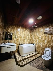 ein Badezimmer mit einer Badewanne, einem Waschbecken und einem WC in der Unterkunft KEMBARA RESORT in Setiu