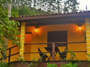 a yellow house with a balcony with a television at Chalé eldorado in Capela Ivapurunduva