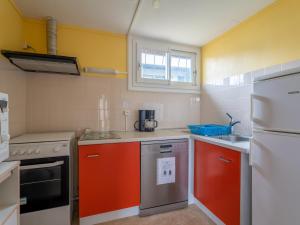 a small kitchen with orange and white appliances at Chalet cosy pour 4 pers à Mimizan, proche plages et pistes cyclables, classé 2 étoiles - FR-1-50-108 in Mimizan