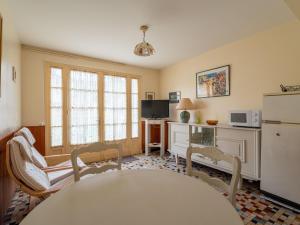 a kitchen with a table and chairs and a refrigerator at Appartement 4 pers, Pieds des Pistes Cyclables, Terrasse, BBQ, Proche Plages et Activités - FR-1-50-107 in Mimizan