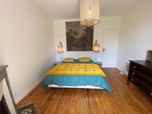 - une chambre avec un lit doté d'une couette jaune et bleue dans l'établissement Villa Arcachon, 4 pièces, 7 personnes - FR-1-374-202, à Arcachon