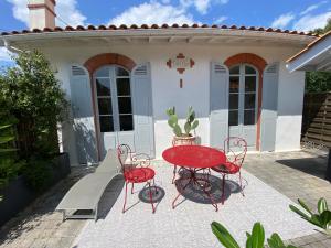 une table et des chaises rouges devant une maison dans l'établissement Villa Arcachon, 4 pièces, 7 personnes - FR-1-374-202, à Arcachon