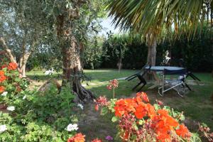 a table and a bench in a garden with flowers at La Convenienza in Cascina