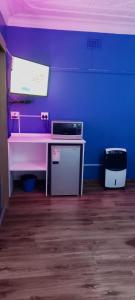 a room with a pink desk and a blue wall at Master Palace Guest House - Randfontien in Randfontein
