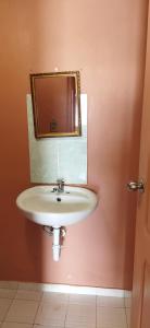 a bathroom with a sink and a mirror at Ofiuras Hostal in Colón