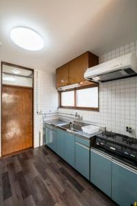 a kitchen with blue cabinets and a sink at HATSUNE in Otaru