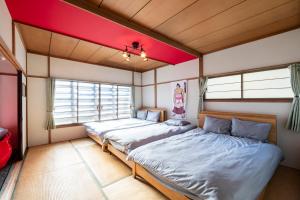 two beds in a room with a red ceiling at HATSUNE in Otaru