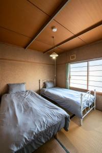 a bedroom with two beds and a window at HATSUNE in Otaru +58 photos