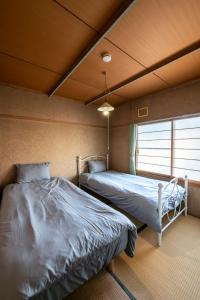 a bedroom with two beds and a window at HATSUNE in Otaru