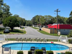 a swimming pool with chairs next to a road at Hunter's Friend Resort Near Table Rock Lake in Branson