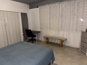 um quarto com uma cama, uma secretária e uma cadeira em 176 Calle Perez (4B2) em San Juan