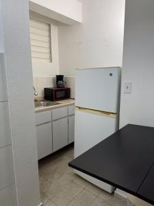 uma cozinha com um frigorífico branco e um lavatório em 176 Calle Perez (4B2) em San Juan