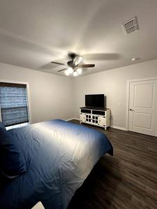 a bedroom with a bed and a ceiling fan at Howdy Hideaway in Magnolia