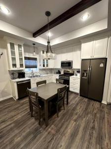 a kitchen with a table and a black refrigerator at Howdy Hideaway in Magnolia