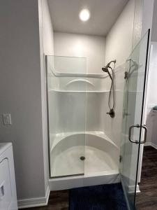 a shower with a glass enclosure in a bathroom at Howdy Hideaway in Magnolia