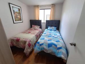 sypialnia z 2 łóżkami i oknem w obiekcie Cálido apartamento, acogedor w Cuzco