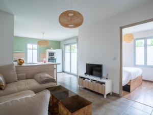 ein Wohnzimmer mit einer Couch und einem Bett in der Unterkunft Appartement Confort pour 4 au Centre de Mimizan – Plage, Lac, et Activités à Proximité - FR-1-50-119 in Mimizan