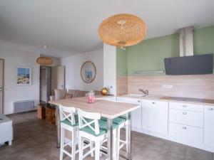 eine Küche mit einem Holztisch und Stühlen in der Unterkunft Appartement Confort pour 4 au Centre de Mimizan – Plage, Lac, et Activités à Proximité - FR-1-50-119 in Mimizan