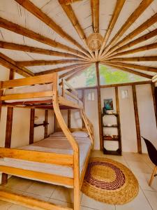 a bunk bed in a room with a wooden ceiling at ITCHIMBIA GARDEN AYAMPE Montaña y Mar in Ayampe