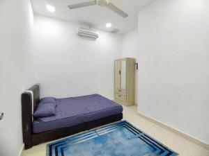 een kleine kamer met een bed en een kast bij Suka Inap Homestay in Kepala Batas
