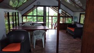 a dining room with a table and chairs and windows at Amaya's Hostel in Jaloba