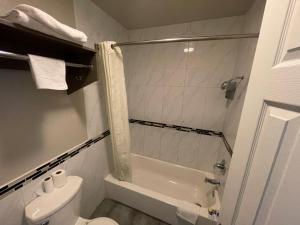 a bathroom with a tub and a toilet and a shower at Economy Inn in San Bernardino
