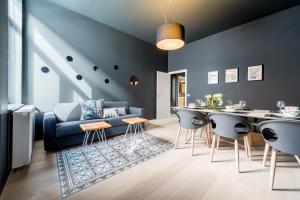 - un salon avec un canapé bleu et une table dans l'établissement Smartflats Design - Cathédrale, à Liège