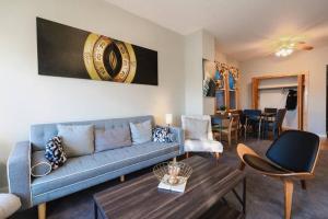 uma sala de estar com um sofá azul e uma mesa em Cityscape Retreat 3BR Haven with Free Parking em Chicago