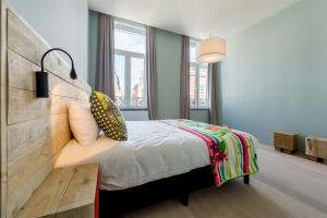 a bedroom with a bed and a large window at Smartflats Design - Cathédrale in Liège
