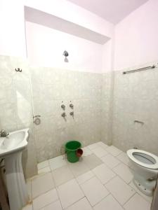 a bathroom with a toilet and a green bucket at Little Prince Home Stay in Jaisalmer