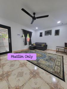 sala de estar con ventilador de techo y alfombra en Homestay Kasih Tok Ayah Sg Petani, en Sungai Petani