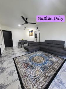 een woonkamer met een bank en een tapijt bij Homestay Kasih Tok Ayah Sg Petani in Sungai Petani