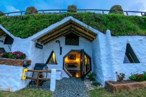 un modelo de casa con techo de hierba en Hobbit Hotel Ecolodge- Guatapé, en Guatapé