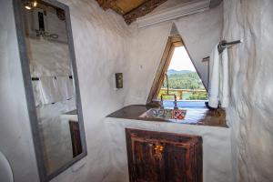 baño con lavabo y ventana en Hobbit Hotel Ecolodge- Guatapé, en Guatapé
