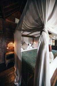 een slaapkamer met een hemelbed bij Villa Ellya in Kuta Lombok