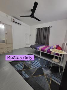 Un dormitorio con una cama y una mesa. en Homestay Kasih Tok Ayah Sg Petani, en Sungai Petani