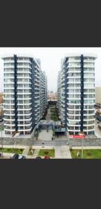 dos rascacielos altos en una ciudad con edificios en Panoramic Aparment San Miguel en Lima