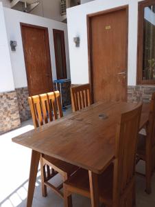 einen Holztisch mit Holzstühlen und einer Holztür in der Unterkunft Amelle Villas & Residences Canggu in Canggu
