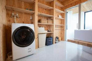 熱海市にある&y,atami - Vacation STAY 36193vの木製の壁の客室で、洗濯機と乾燥機が備わります。