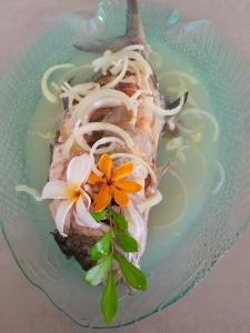 um prato de comida com um pedaço de peixe e macarrão em Maupiti Dreams em Te-Fare-Arii